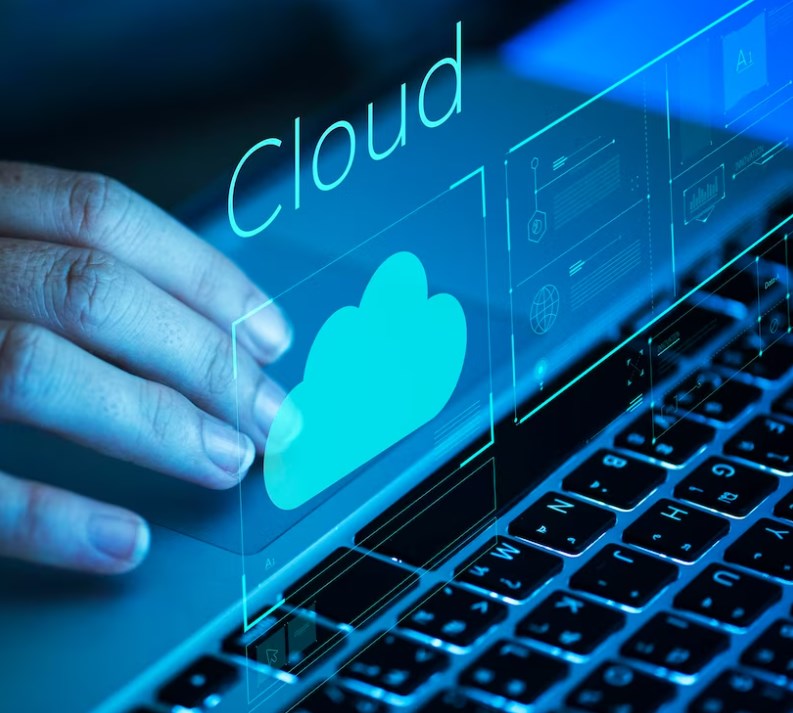 a woman’s hand scrolling on a laptop with virtual windows and the word “Cloud” above the keyboard
