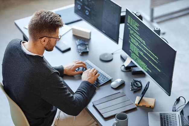 A man is programming and looking at a computer